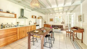 A spacious kitchen with wooden cabinets, a central island, and a dining area with stools.