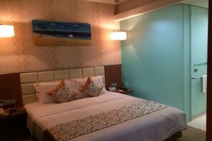 A hotel room with a bed, a nightstand, a wall-mounted painting, and a light fixture. - Shanshui Trends Hotel (Guangzhou Huangpu East Road Dasha East Subway Station) (Guangzhou)