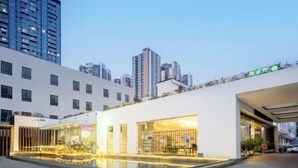 A modern hotel with a swimming pool, large windows, and a city skyline in the background. - Shanshui Trends Hotel (Guangzhou Huangpu East Road Dasha East Subway Station) (Guangzhou)