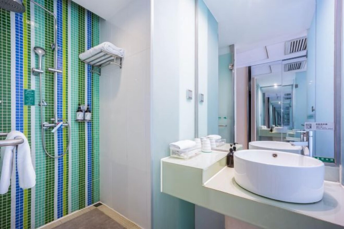 A modern bathroom with a shower, a sink, and a mirror.