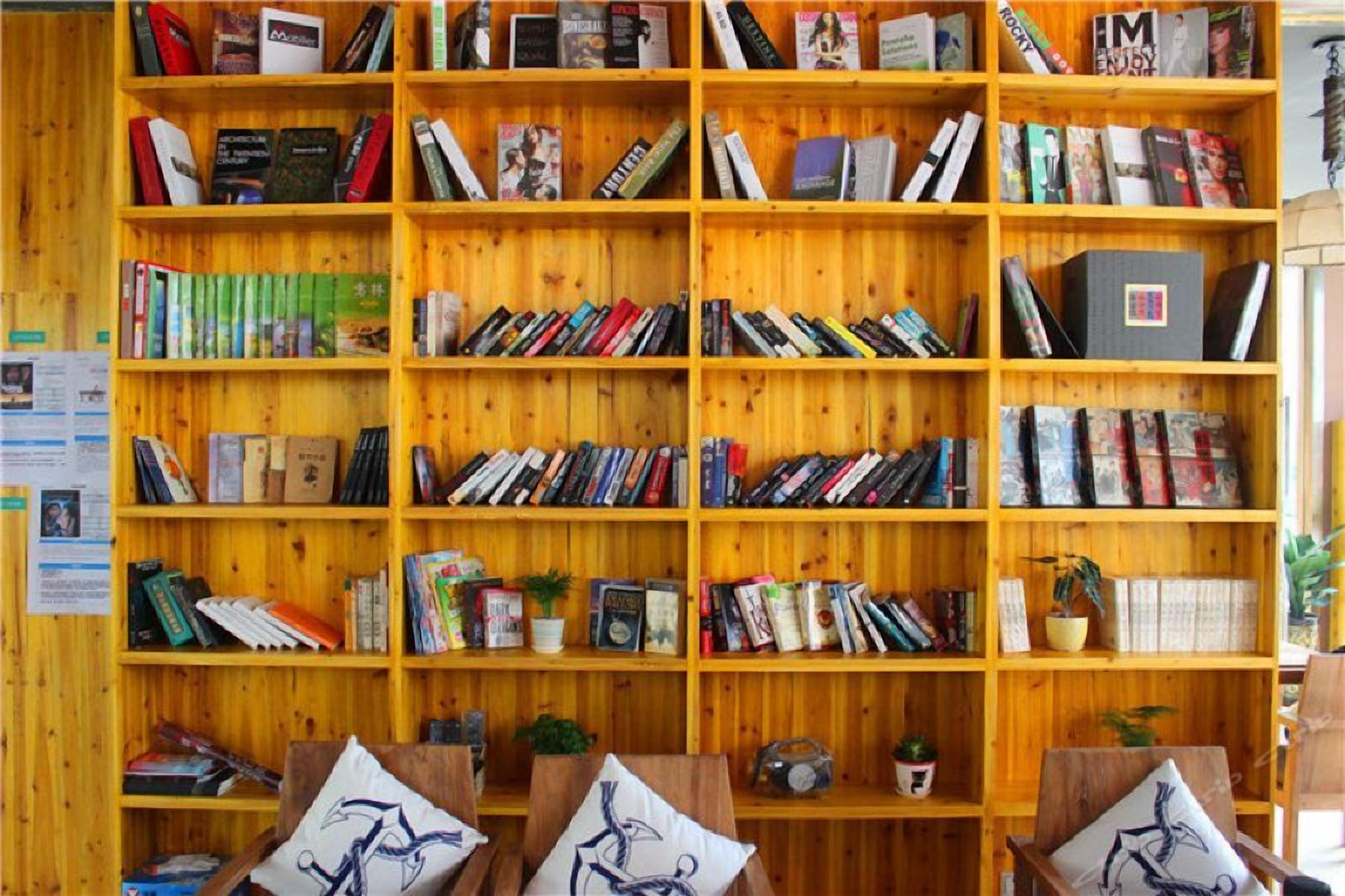 Una estantería de madera llena de libros y algunos objetos decorativos.
