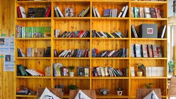 Una estantería de madera llena de libros y algunos objetos decorativos.