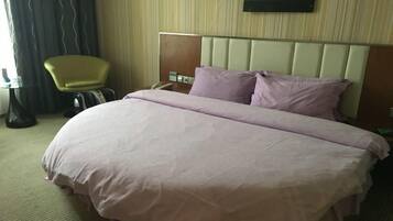 Une chambre d’hôtel avec un lit, une chaise, un bureau et un téléphone.