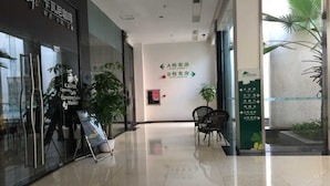 Un pasillo de hotel con señales indicativas hacia habitaciones y servicios.