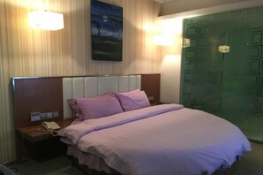 A hotel room with a bed, a nightstand with a telephone, and a wall-mounted lamp. - Shanshui Trends Hotel (Guangzhou Huangpu East Road Dasha East Subway Station) (Guangzhou)
