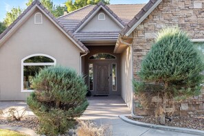 A house with a stone facade, a gabled roof, and a front door.