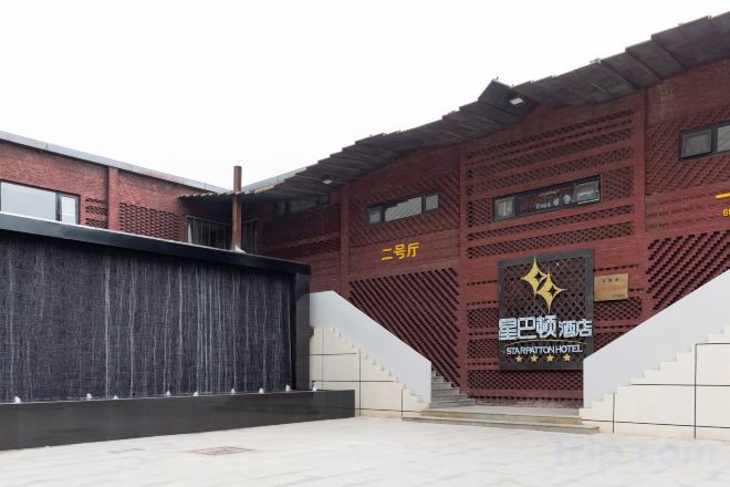 A building with a red brick facade, a staircase leading to the entrance, and a sign indicating the name of the establishment.