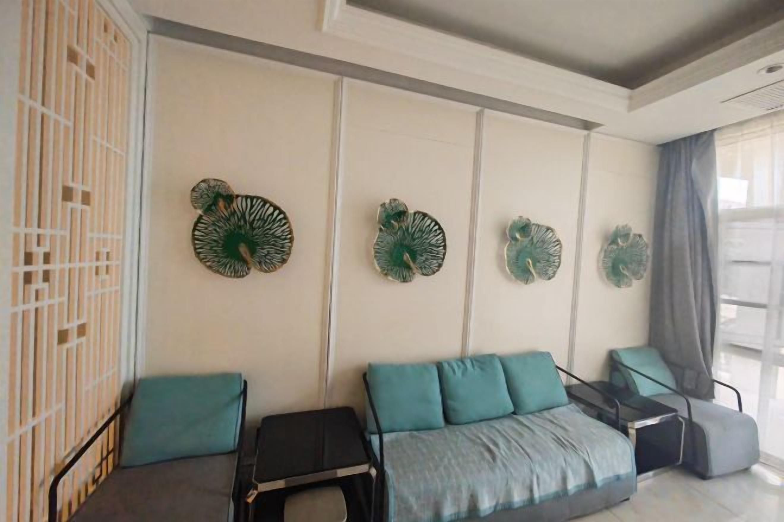 A modern living room with a sofa, two armchairs, a coffee table, and decorative wall art.