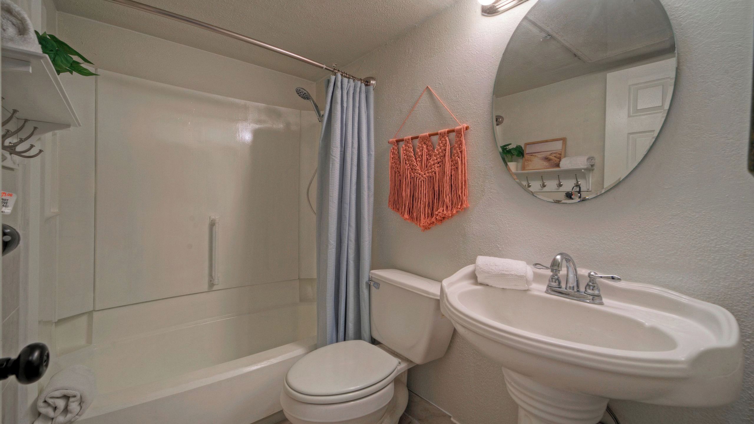 Ein Badezimmer mit Dusche, Toilette, Waschbecken und Spiegel.