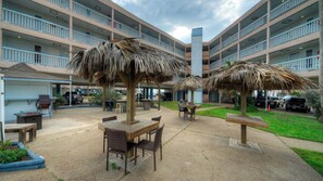 A courtyard with outdoor seating, a pool, and a multi-story building with balconies.