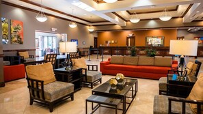 Eine Lobby mit Empfangsschalter, Sitzgelegenheiten und einem großen, roten Sofa.