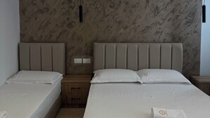 A modern hotel room with two single beds, a marble-patterned headboard, and a minimalist design. - Hotel Moonlight (Vlorë)