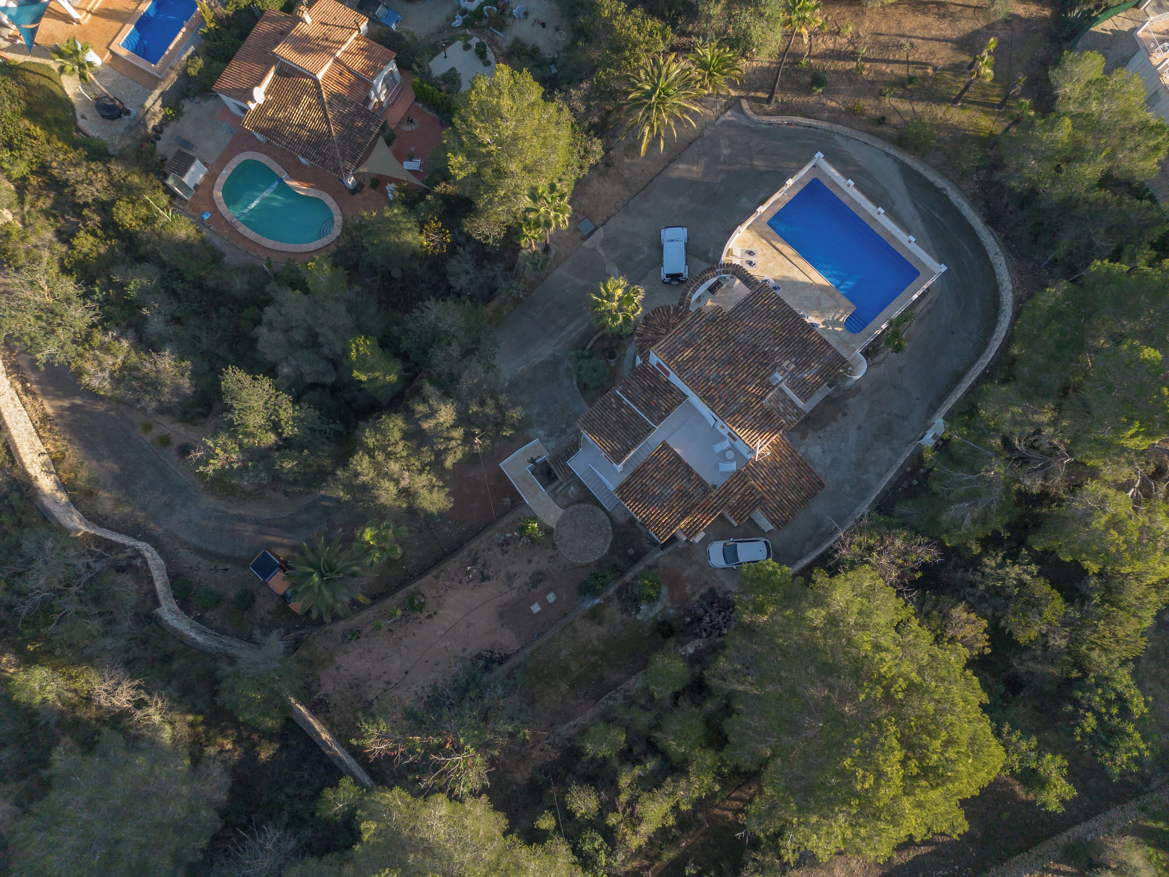 Eine Vogelperspektive eines Wohnhauses mit Swimmingpool, Terrassenbereich und großem Garten.