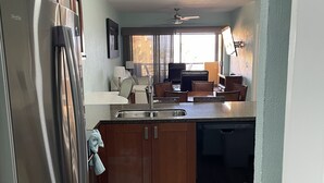 A compact kitchen with a refrigerator, dishwasher, and wooden cabinets. - RockyCondo - Princesa A-407 Beach Front 2 Bed 2 Bath Condo (Puerto Penasco)