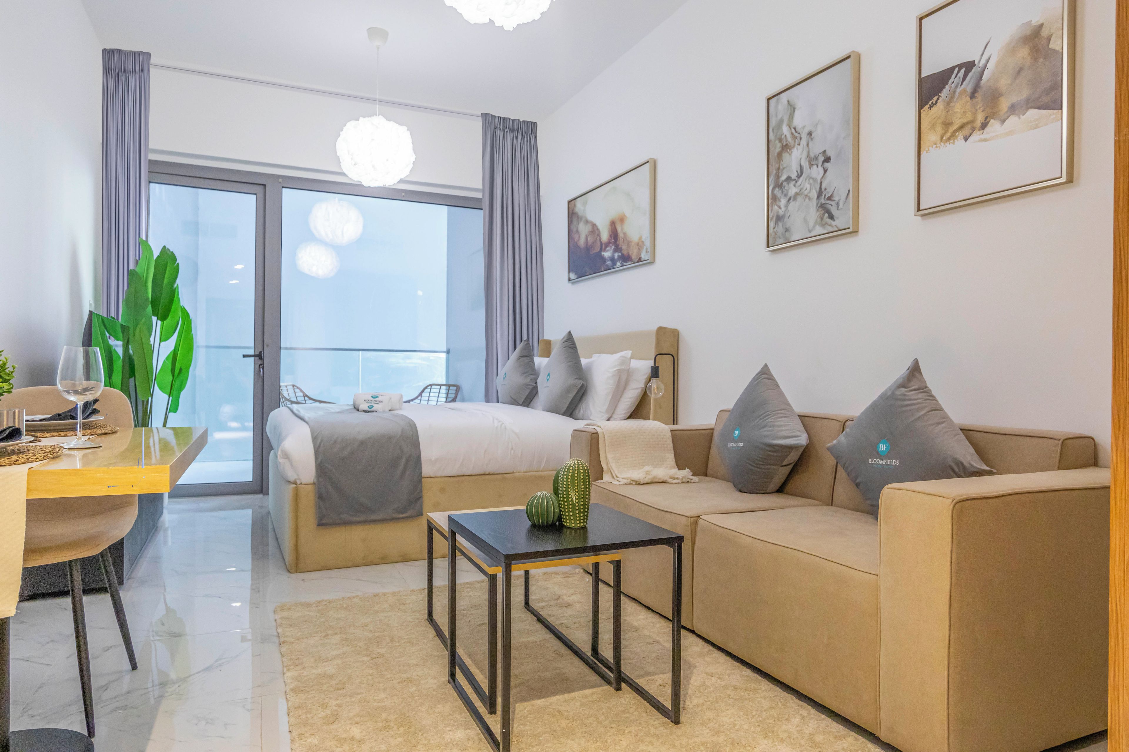 Una habitación de hotel moderna con una cama, un sofá, una mesita de centro y un rincón comedor con mesa y sillas.