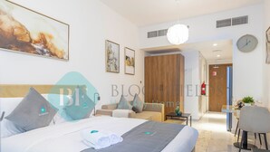 Une chambre d’hôtel moderne dotée d’un grand lit, d’un bureau et d’un coin repas.