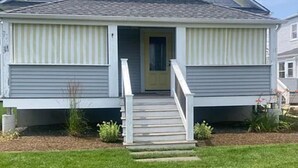 A single-story house with a front porch, a door, and a small front yard with plants. - Walk to Beach & Festivities All Summer at the Jersey Shore! (Long Branch)