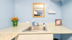 Une salle de bain équipée d’un lavabo, d’un miroir et d’articles de toilette.