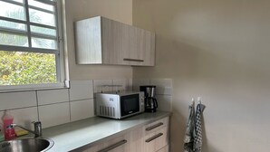 A kitchen with a microwave, coffee maker, and a sink. - Apartment centrally located near Mambo beach Curacao (Willemstad)