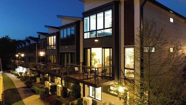 A modern multi-story residential building with large windows, balconies, and outdoor lighting. - Luxe 4bdr w/ Balcony & Parking, 10 Mins to Broadway 9th Avenue by Avantstay (Nashville)
