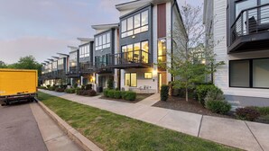 A row of modern multi-story residential buildings with balconies, a paved driveway, and a truck parked on the street. - Luxe 4bdr w/ Balcony & Parking, 10 Mins to Broadway 9th Avenue by Avantstay (Nashville)
