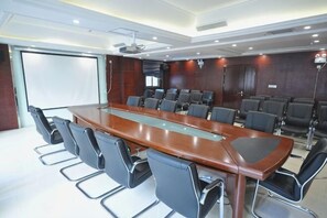 A conference room with a long table, multiple chairs, a projector screen, and a large window. - Lanzuan Hotel (Ankang)
