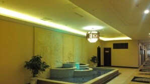 A hotel lobby with a central water feature, a chandelier, and a reception desk. - Lanzuan Hotel (Ankang)