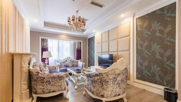A living room with a sofa set, a television, and a decorative wall panel. - Lanzuan Hotel (Ankang)