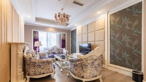 A living room with a sofa set, a television, and a decorative wall panel. - Lanzuan Hotel (Ankang)