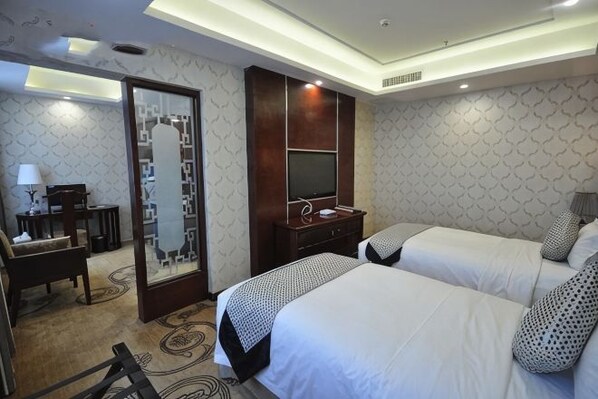 A hotel room with two beds, a desk, a chair, a TV, and a mirror. - Lanzuan Hotel (Ankang)