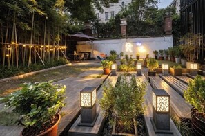 Un patio al aire libre con macetas y luces decorativas.