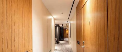 A hotel hallway with wooden walls, a carpeted floor, and a sign indicating room number 606.
