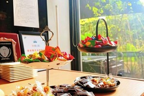 Una mesa con diferentes alimentos y una ventana que ofrece vistas a la vegetación.