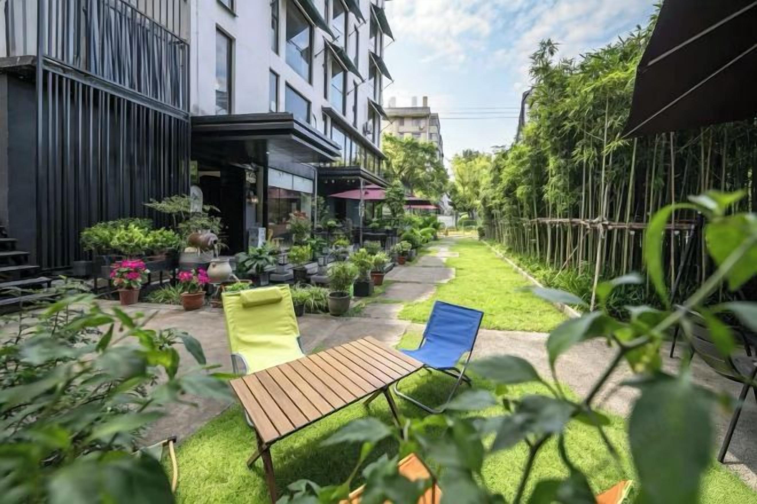 A courtyard with a seating area, potted plants, and a building facade.
