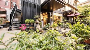 A modern building with a staircase, outdoor seating, and potted plants.