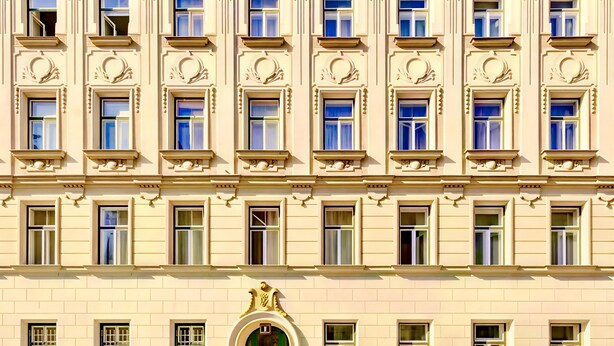 A multi-story building with a symmetrical facade, large windows, and a central green door with ornate detailing. - Art Living Vienna (Vienna)