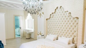 A spacious bedroom with a large bed, a chandelier, and a mirror. - Shapira Boutique Hotel (Buxoro)