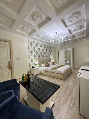 Habitación de hotel con cama, mesita de noche y lámpara de araña.