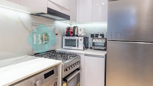 Une cuisine moderne équipée d’appareils électroménagers en acier inoxydable, d’un four encastré et d’un four à micro-ondes.