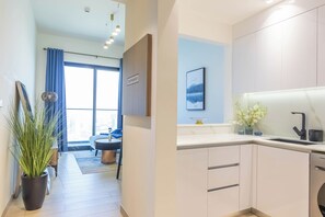 A modern kitchen with white cabinets, a built-in dishwasher, and a sink with a modern faucet.