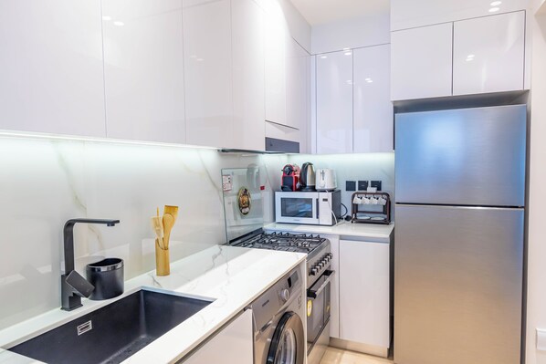 A modern kitchen with stainless steel appliances, a built-in oven, and a microwave.