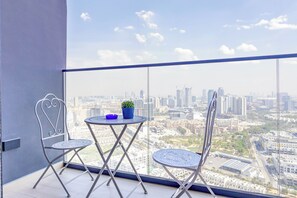 Ein Balkon mit zwei Stühlen, einem kleinen Tisch und einem Blumentopf.