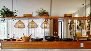 Una encimera de cocina con utensilios, una cafetera y luces colgantes.