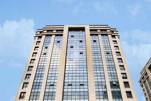 A tall, modern building with a grid of windows and a flat roof. - Yinggeli Hotel (Zhengzhou East Railway Station Convention and Exhibition Center) (Zhengzhou)