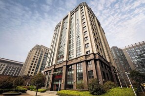 A high-rise building with multiple floors, large windows, and a prominent entrance.