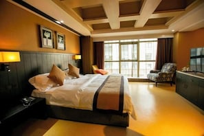 A hotel room with a large bed, a desk with a lamp, a chair, and a TV. - Yinggeli Hotel (Zhengzhou East Railway Station Convention and Exhibition Center) (Zhengzhou)