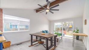 A spacious room with a large dining table, a ceiling fan, and a view of the outside. - Cozy Family Haven in Sparks - Pet Friendly - Fenced Yard (Sparks)