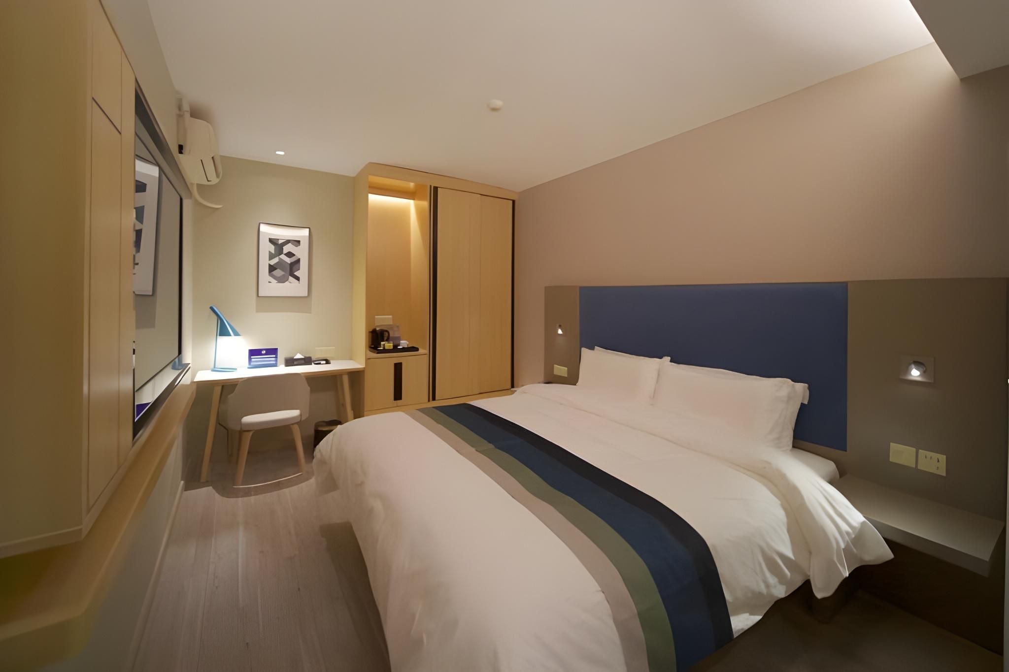 Een hotelkamer met een bed, een bureau en een stoel.