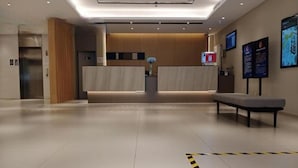 A hotel lobby with a reception desk, a bench, and a clear floor path. - Homeinn Selected Hotel (Beijing Shangdi Qinghe Subway Station) (Beijing)