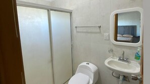 Une petite salle de bain avec des toilettes, un lavabo et un miroir.